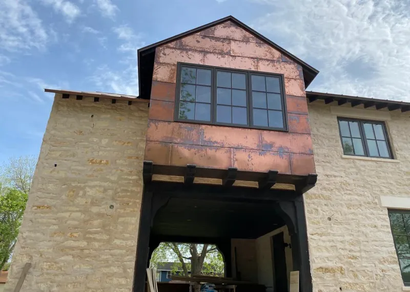 Copper metal panel facade on a stone building for Roof Repair in Minnetrista